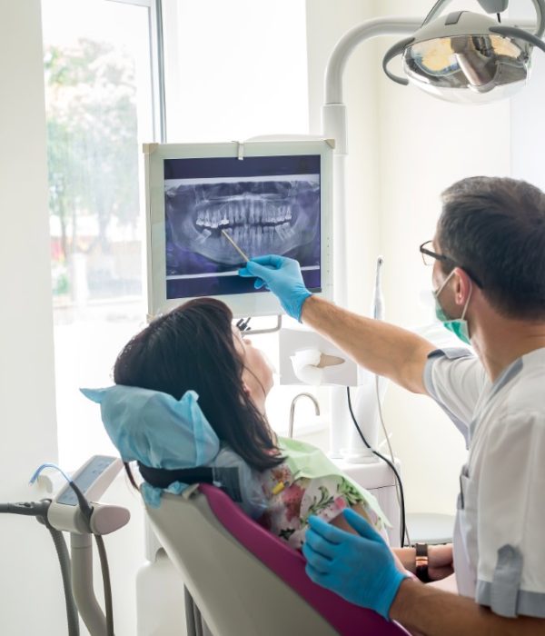 Doctor dentist showing patient's teeth on X-ray