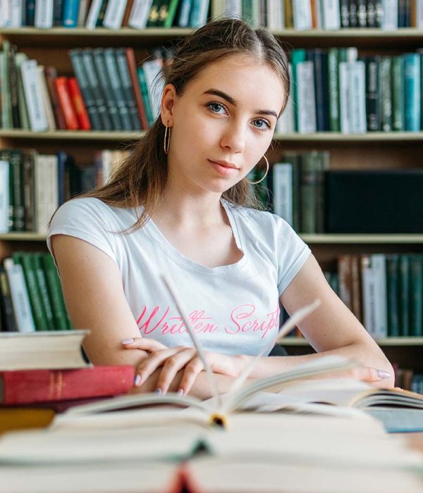 Back to school, reading book, education, library concept. Student girl with book on background of bookshelves in the library