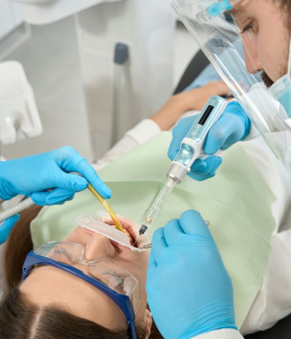 focused-doctor-administering-local-anesthesia-to-young-woman